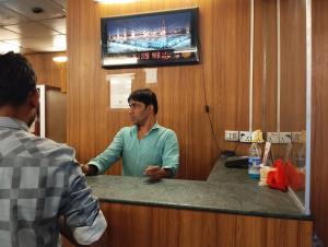 a man standing at a counter in an office at Hotel Indropuri International in Dhaka