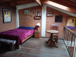 a bedroom with a bed in a brick wall at "Arte en el desván" Rustic loft - Desván rústico in Tenancingo de Degollado