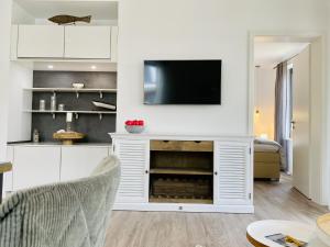 a living room with a television on a white entertainment center at Ferienwohnung Ostseeliebe Parkvillen Carlota und Candela Baabe in Baabe