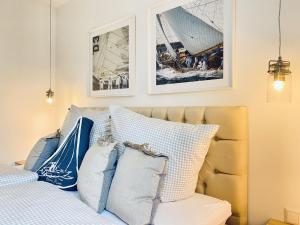 a bedroom with a bed with blue and white pillows at Ferienwohnung Ostseeliebe Parkvillen Carlota und Candela Baabe in Baabe