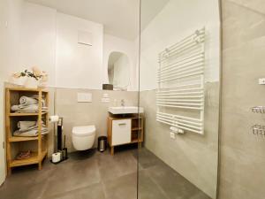 a bathroom with a toilet and a sink and a shower at Ferienwohnung Ostseeliebe Parkvillen Carlota und Candela Baabe in Baabe +12 photos