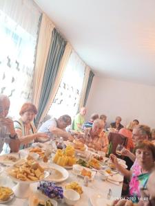 a group of people sitting at a table eating food at Satina Jenish in Syn-Tash +15 photos