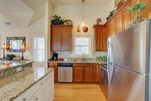 a kitchen with a stainless steel refrigerator and wooden cabinets at 6156 - Family Tides in Nags Head +43 photos