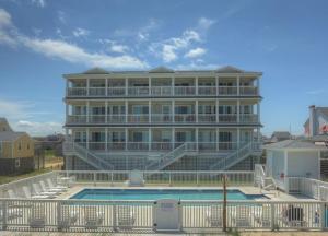 a large building with a swimming pool in front of it at TSC404 - Seaclusion in Kill Devil Hills