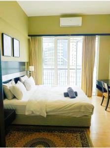 una camera da letto con un letto grande con una grande finestra di Seri Bukit Ceylon Dreamy Destiny luxe Suites a Kuala Lumpur
