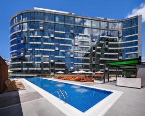 a large building with a swimming pool in front of it at The Darling at The Star in Sydney