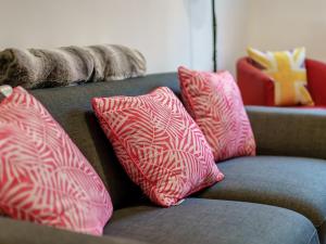 a couch with pink and white pillows on it at Fisherman's Rest in Broadstairs