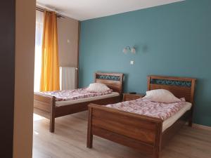 deux lits dans une chambre aux murs bleus dans l'établissement Free Parking Pension, à Oradea