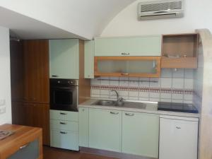 a kitchen with white cabinets and a sink at Casa Vacanze Bouganvillea in Cetara
