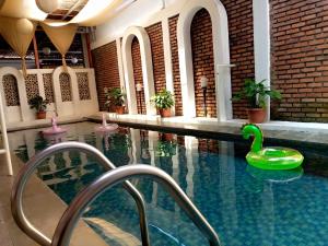 a swimming pool with a green swan in the water at villa Ambarwati in Maleber 1