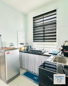 a kitchen with a refrigerator and a window at Homestay AZ Kulim in Kulim