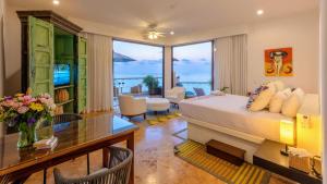 a hotel room with a bed and a dining room at Villa Divina Luxury Boutique - Adults Only in Puerto Vallarta +106 photos