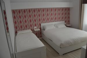 1 dormitorio con 1 cama y pared roja y blanca en In Centro Glam, en Bérgamo