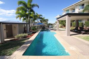 a swimming pool in front of a house at Caloundra Central Apartment Hotel Official in Caloundra