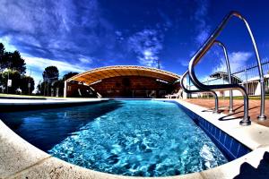 a swimming pool with a building in the background at Wavecrest Village & Tourist Park WA in Hopetoun
