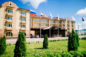 un hotel con banderas frente a un edificio en Admiral Hotel, en Saransk