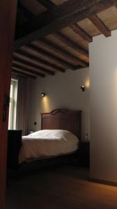 1 dormitorio con 1 cama con cabecero de madera en Hotel Guesthouse Begijnhof, en Lovaina