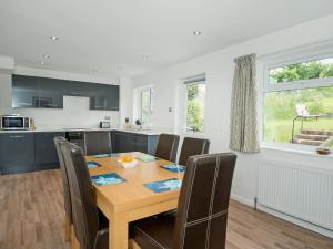 a kitchen and dining room with a wooden table and chairs at Little Orchard in Farmborough