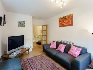 a living room with a couch and a flat screen tv at Fisherman's Rest in Broadstairs