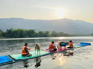a group of people and a dog on a paddle board in the water at Freezone Glamping in Da Nang