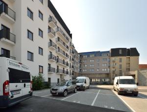 un estacionamiento con autos estacionados frente a un edificio en Charming & Cozy Ambiente Apartments, en Bratislava