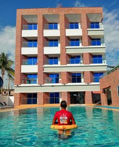 a man in a pool in front of a building at Best Southern Hotel in Kuākāta
