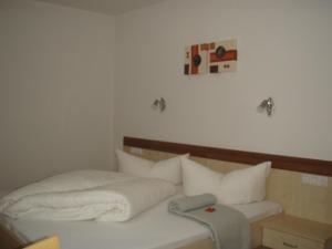 a bedroom with a bed with white sheets and pillows at Apart Schultes in Pettneu am Arlberg