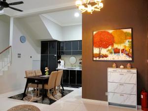 a dining room with a table and a painting on the wall at Sarrah Homestay At Kasa Height Residence in Kampong Alor Gajah +57 photos