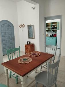 a dining room with a table and chairs and a kitchen at White Cat in Vromolithos