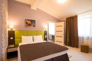 a bedroom with a bed with a green headboard at Apart Hotel Yesenin in Kurgan