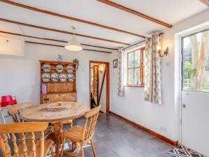 Rookery Cottage في Little Staughton: مطبخ وغرفة طعام مع طاولة وكراسي
