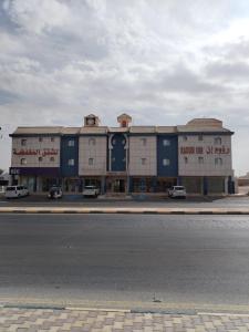 un edificio al costado de una carretera con una calle en رؤوم إن للشقق المخدومة - Raoum Inn Serviced Apartments-Hotah, en Hotat bani tamim