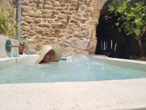 a woman in a jacuzzi in a hot tub at Maison de village à deux pas de la rivière in Remoulins +26 photos