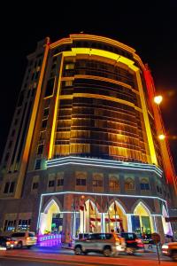 a building with cars in front of it at night at Grand Regal Hotel in Doha