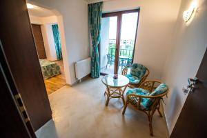 a room with a table and chairs and a balcony at Elina in Techirghiol