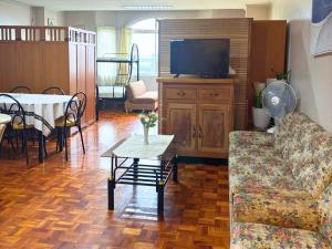a living room with a couch and a table and a tv at Big Condo Unit Baguio Near Burnham Park in Baguio