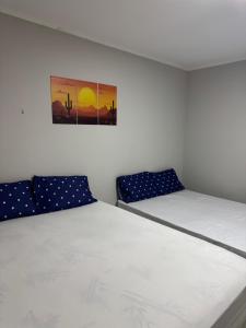 a bedroom with two beds and a painting on the wall at Casa Lanôh in Canindé de São Francisco