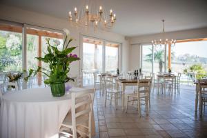 une salle à manger avec tables et chaises et un lustre dans l'établissement Locanda Corte Montioni, à Lazise