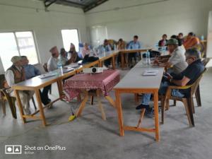 a group of people sitting at tables in a room at Fish O Farm Guest House in Jhawāni