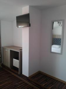 a room with a television and a mirror on a wall at Hotel La John in Vama Veche +56 photos