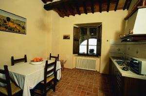 uma cozinha com uma mesa e uma cozinha com uma mesa e cadeiras em Le Piane em Castiglione dʼOrcia