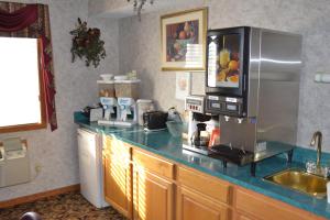 a kitchen with a counter with a microwave and a refrigerator at Relax Inn Motel and Suites Omaha in Omaha