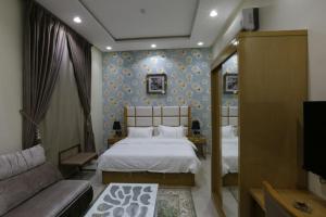 ein Schlafzimmer mit einem Bett und einer Couch in der Unterkunft أجنحة درة Dorra Suites in Riad