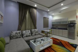 ein Wohnzimmer mit Sofa und eine Küche in der Unterkunft أجنحة درة Dorra Suites in Riad