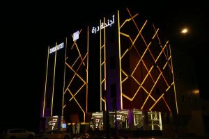 利雅德أجنحة درة Dorra Suites的一座晚上有灯的建筑