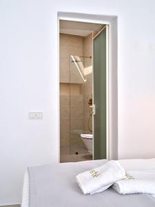a bedroom with a bed and a bathroom with a shower at Este Naousa in Naousa