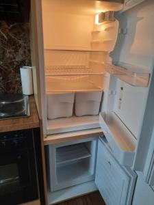 an empty refrigerator with its door open in a kitchen at Sunny Days Cozy and Comfortable Apartment in Boutersem +19 photos