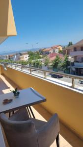 a table and chairs on a balcony with a view at Italian style Apartment in Durrës