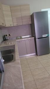 a kitchen with a purple refrigerator and a tile floor at Italian style Apartment in Durrës