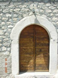 - une porte de garage en bois dans un bâtiment en pierre dans l'établissement Casino Tonti Iarussi, à Forlì del Sannio